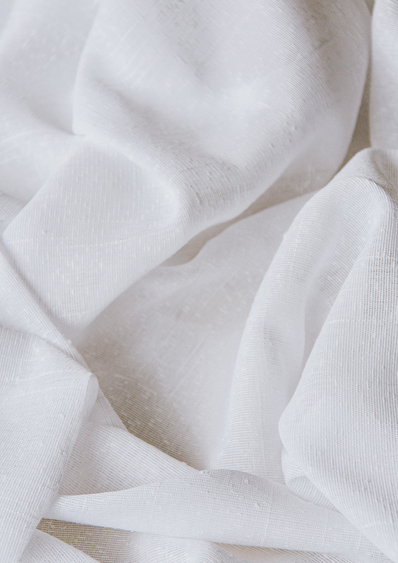 Close-up of BORN Snow curtain bouclé fabric showing its weave.