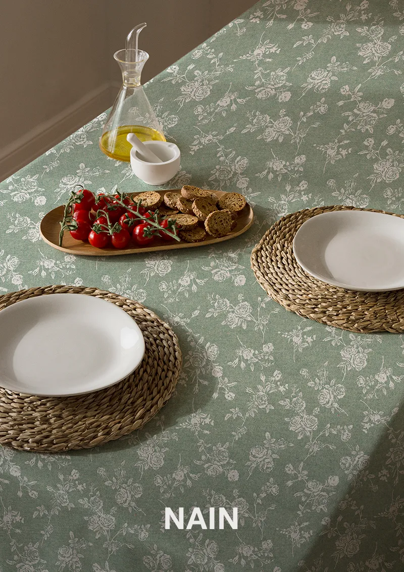 Mantel ZREE Naim con nombre sobre la imagen, flores blancas sobre fondo color lago.