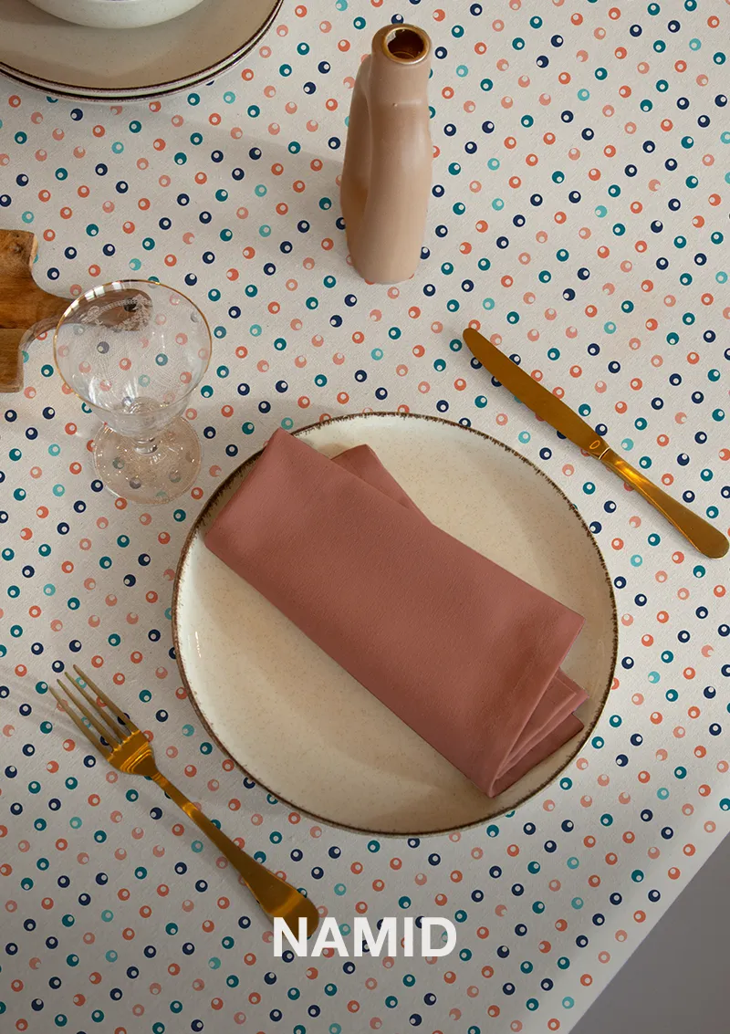 Mantel ZREE Namid con nombre visible, estampado de topos azules, naranja y agua.