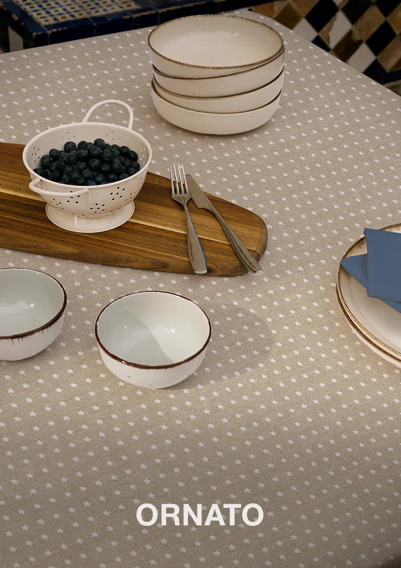 Mantel ZREE Ornato, estrellas blancas sobre fondo beige, con texto del diseño visible.