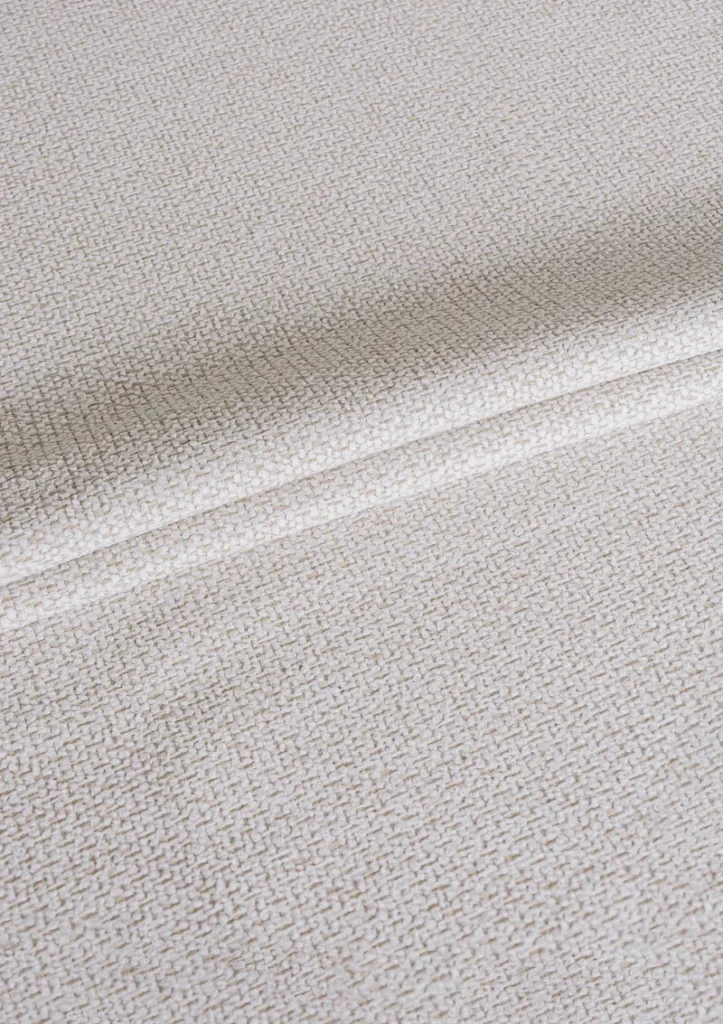 Close-up of Alika outdoor fabric showing textured weave and water-repellent finish in a solid color.