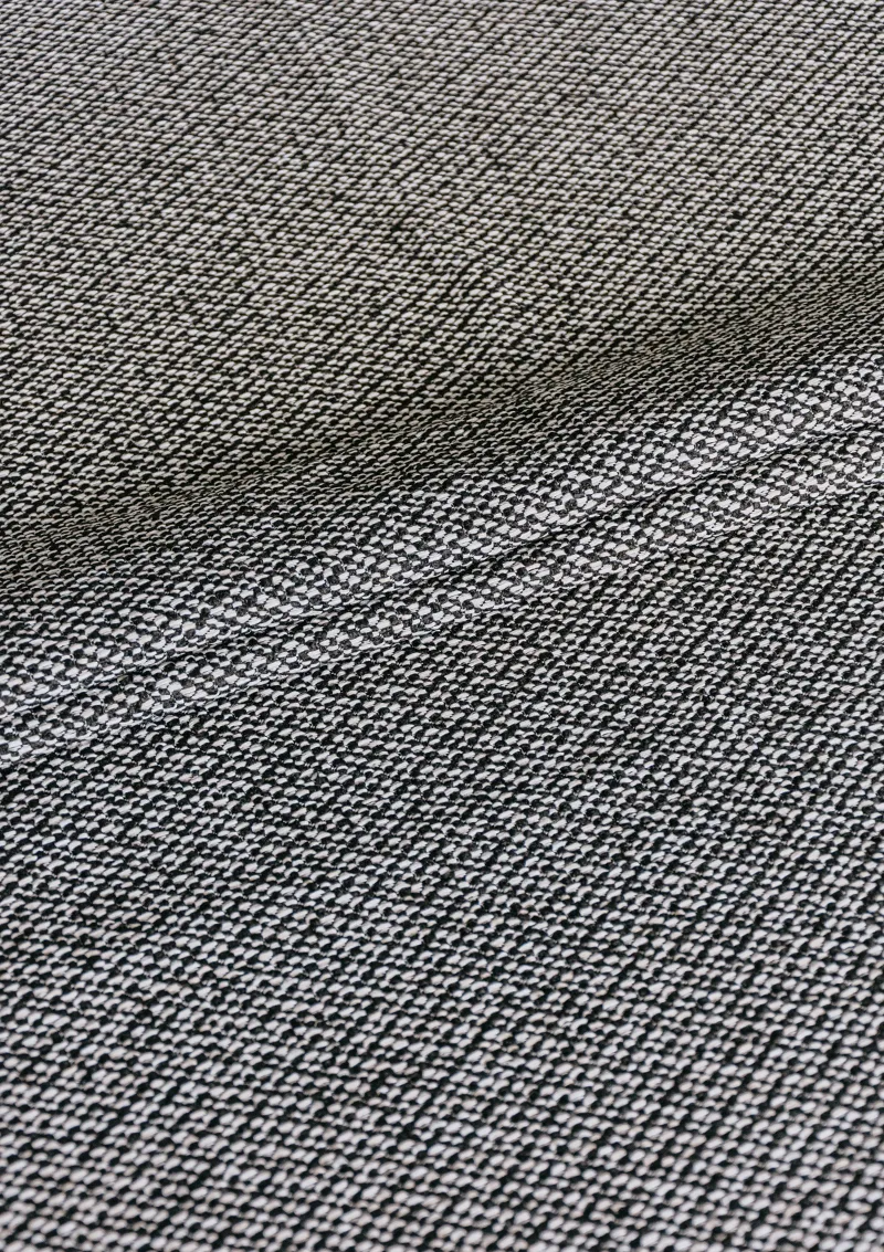 Close-up of Alika outdoor fabric showing textured weave and water-repellent finish in a solid color.