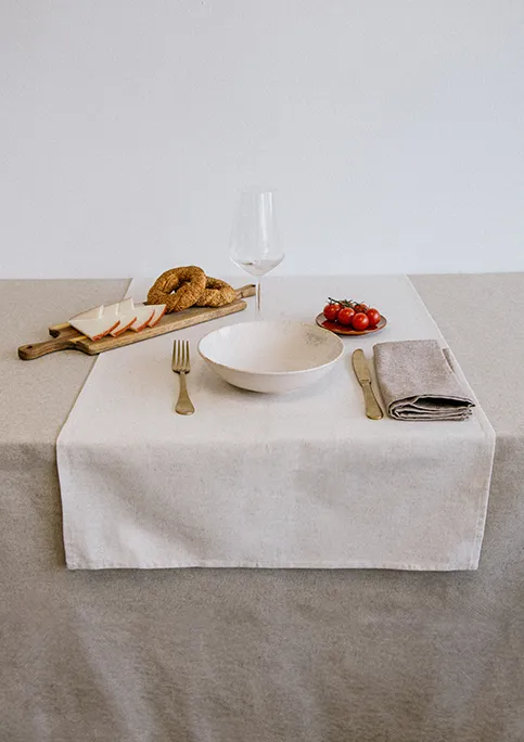 Table setting with beige LAGOS tablecloth, natural SANGOBI table runner and brown LAGOS napkins.