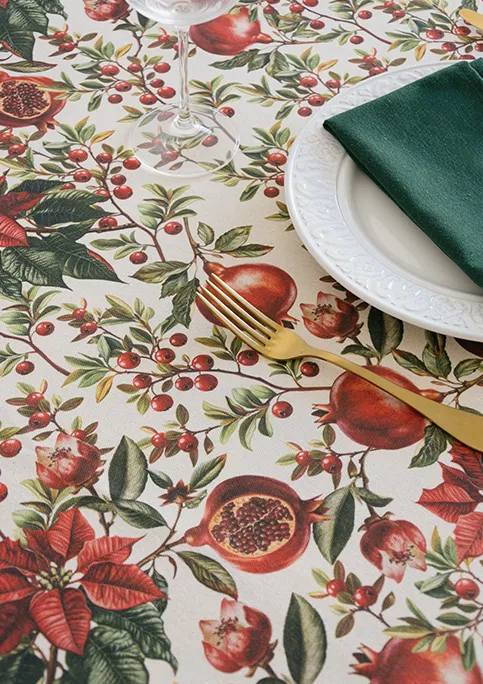 AYLON fabric, from GRENAT Collection. A bold botanical design featuring poinsettias and pomegranates. The red tones are more prominent here, giving the pattern a fuller and more decorative presence.
